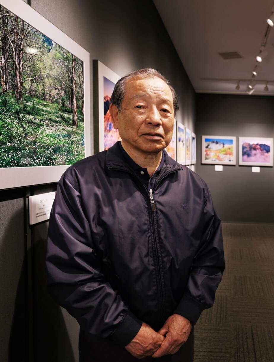 写真展会場で石橋修致様と奥様が並ぶ様子