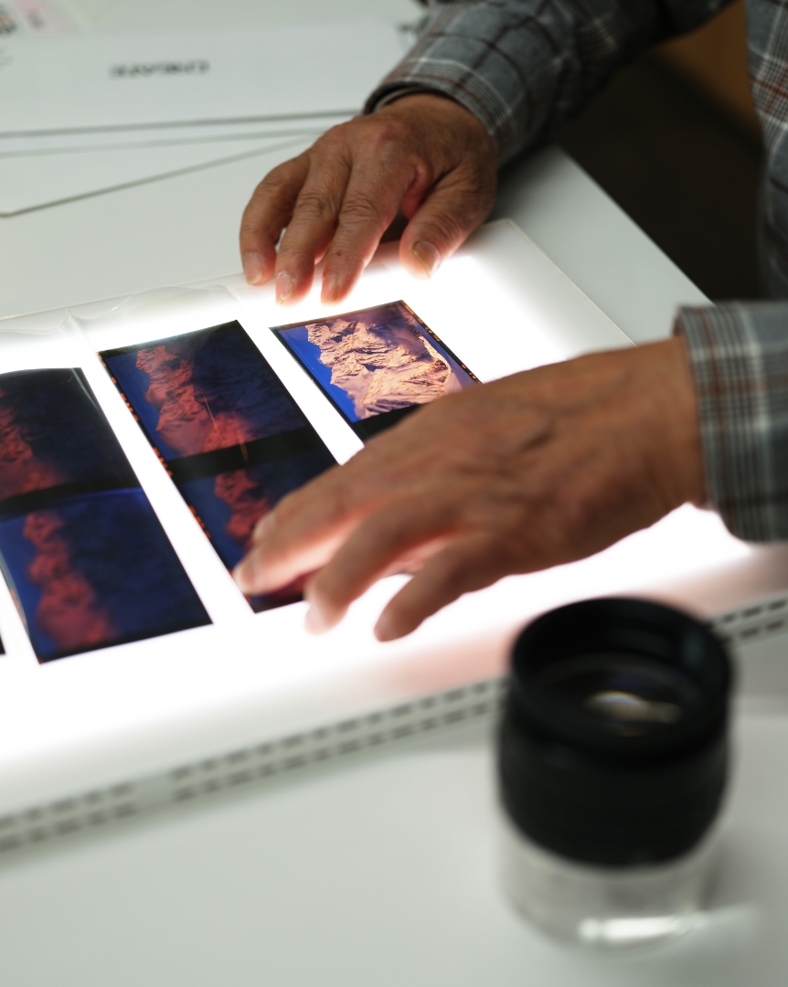 ライトテーブルで写真フィルムを確認する手元